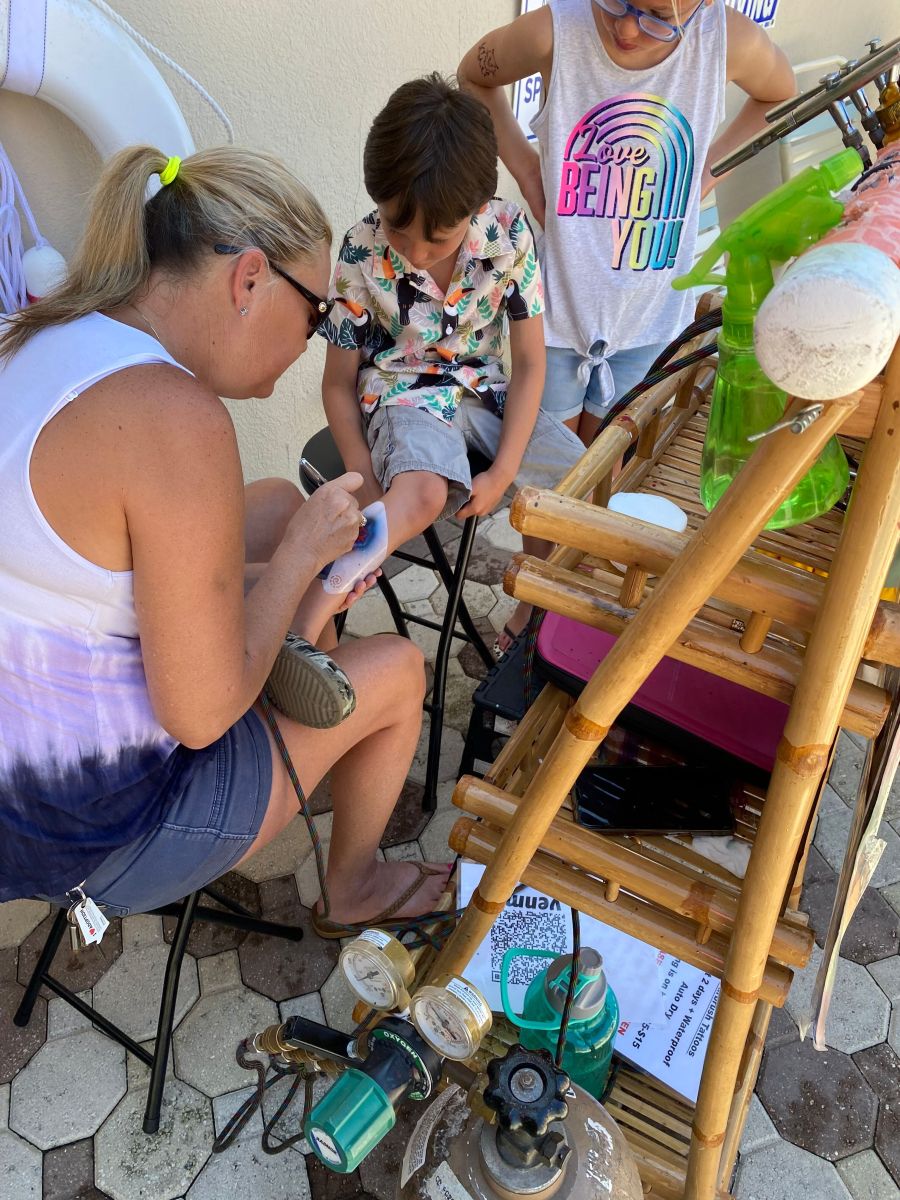 kid getting an airbrush tattoo