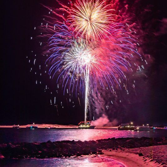 Fireworks from a boat on the water right near the resort
